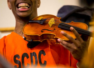 Prisonnier de la SCDC qui joue du violon